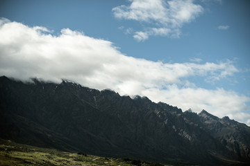 Landscape of shady mountains with huge clouds over them. day shot with blue sky.