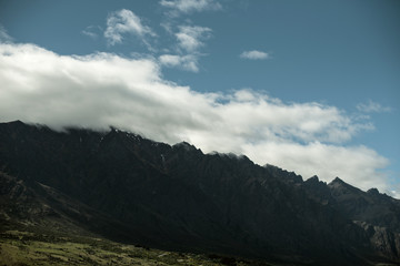 Landscape of shady mountains with huge clouds over them. day shot with blue sky.