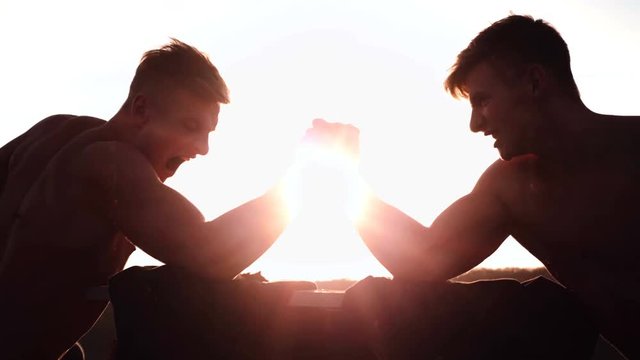 Two men with hands clasped in arm wrestling challenge. Bodybuilding concept