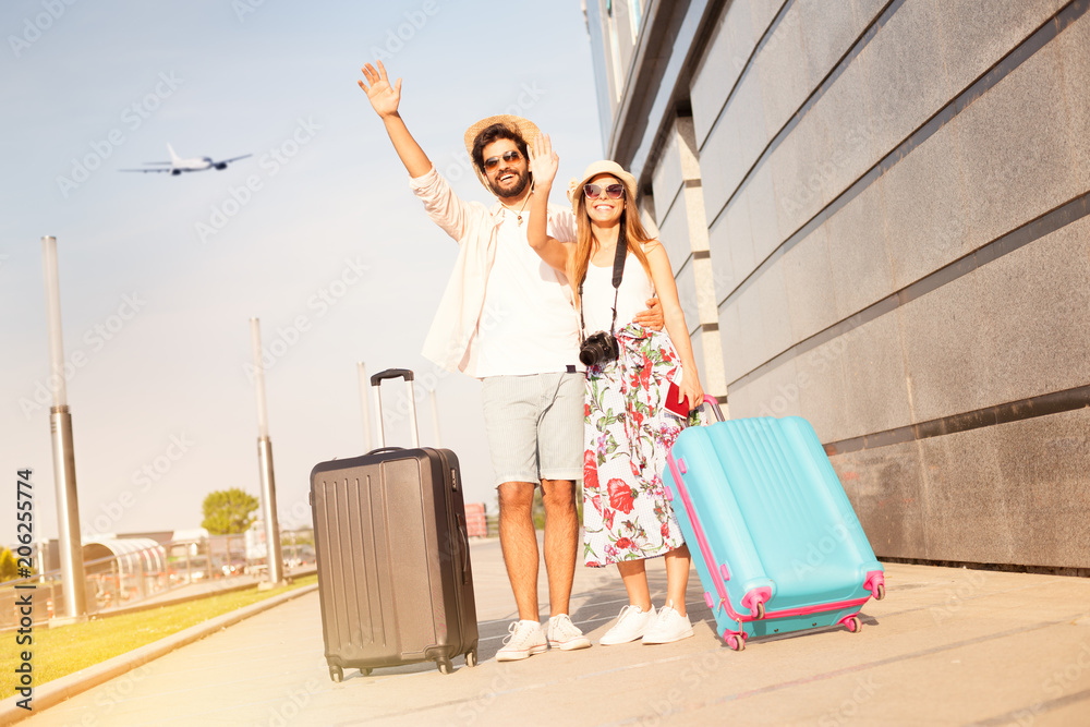 Wall mural young couple says goodbye at the airport, before going on vacation