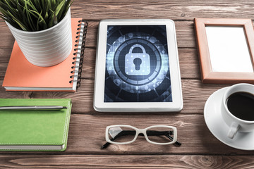 Naklejka premium Web security and technology concept with tablet pc on wooden tab