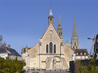 Fototapeta premium Facade of church of Saint-Pierre with the cadral Notre-Dame in the background of Chartres, a commune and capital of the Eure-et-Loir department in region Centre-Val de Loire in France.