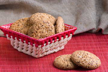 Savory cookies sprinkled with sesame seeds, sunflower on table and burlap background