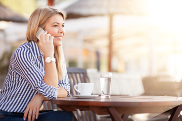 Beautiful busy woman phoning and drinking morning coffee