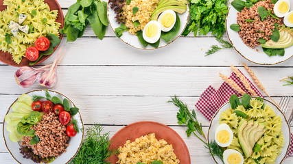 A set of food from buckwheat, bulgur and pasta. On a wooden background. Top view. Copy space.