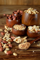 Whole and shredded peanuts in wooden bowls