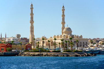 Seascape with a mosque on the shore of the harbor in the Arab city. Hurghada, Egypt