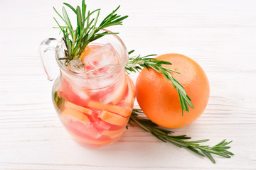 Refreshing summer detox cocktail of grapefruit and rosemary, on white background, copy space