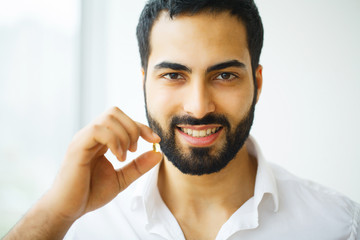 Obraz premium Beautiful Man Taking Pill, Medicine. Vitamins And Supplements