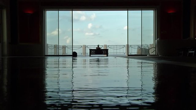 Beautiful view of a spa balcony seen from within the swimming pool as a swimmer is silhouetted in the pool