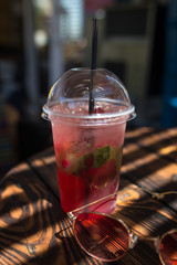 Summer refreshing cocktail outdoors in sunlight and shade