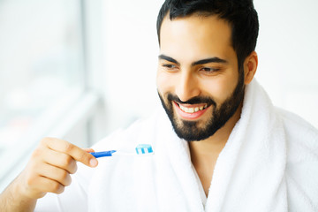 Beautiful Smiling Man Brushing Healthy White Teeth With Brush. High Resolution Image