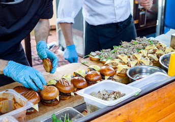 Obraz na płótnie Canvas Street fast food. Cooks prepare different burgers in outdoors