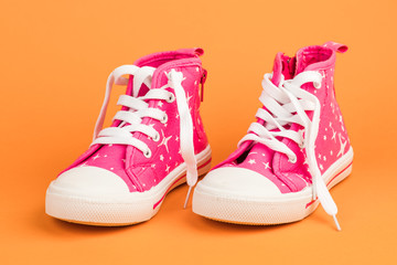 Red children's shoes. On orange background