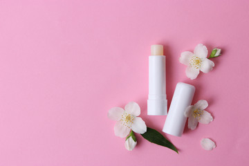 lip balm and flowers on a colored background. minimalism, the top - obrazy, fototapety, plakaty