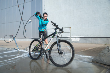 Fototapeta premium young sport woman washing bicycle at self-service car wash