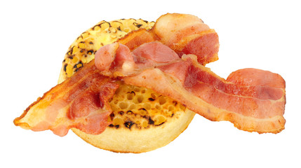 Crispy streaky bacon rashers on a English crumpet isolated on a white background