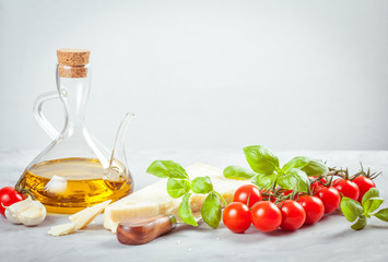 Bunch of fresh basil, tomatoes, parmesan cheese, garlic and olive oil - traditional ingredient of italian cuisine