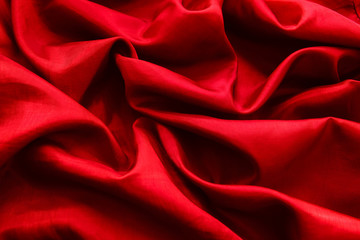 Red satin or silk fabric with folds for the background.