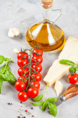 Bunch of fresh basil, tomatoes, parmesan cheese, garlic and olive oil - traditional ingredient of italian cuisine