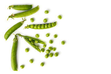 Green peas in pods and scattered on a white. The view from the top.