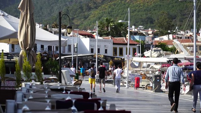People walking and cycling along waterfront at old town in Marmaris. Turkey. 4K.