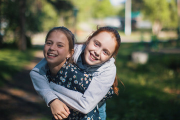 Two girls sisters or girlfriends having fun outdoors. Portraits.