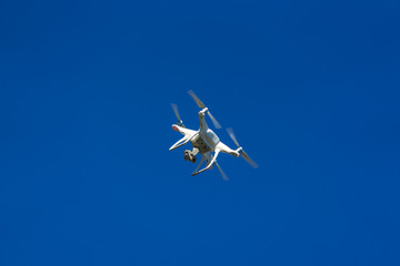 White flying copter against the sky