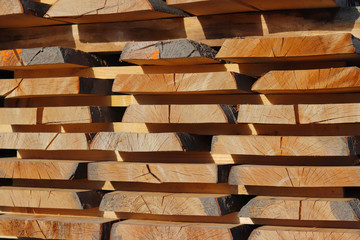 Large wooden planks stacked in racks for drying under the open sky in an industrial area. Timing of wood for carpentry. Manufacture of furniture and wood products. Getting rid of woody moisture.