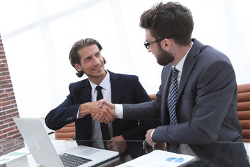 handshake business man sitting behind a Desk.