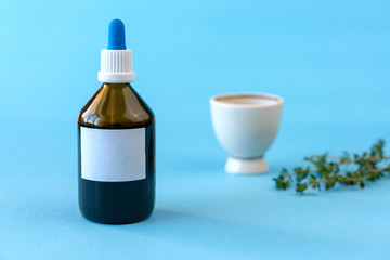 Close-up of a bottle with homeopathic drops. Homeopathic drops for treatment in a glass bottle with clean paper and a pipette