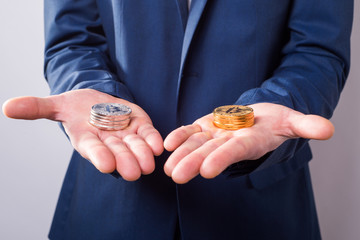 In one hand silver bitcoins, and in another gold bitcoins