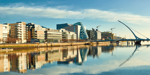 Obraz premium Nowoczesne budynki i biura nad rzeką Liffey w Dublinie w jasny, słoneczny dzień
