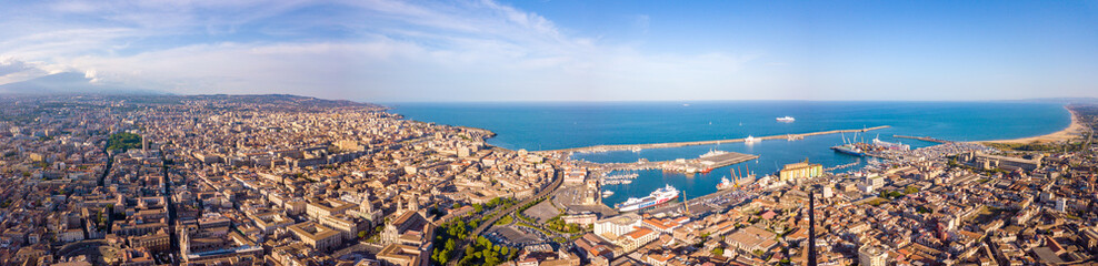 Beautiful aerial view of the Catania city on Sicily from above with Etna volcano visible on the horizon.