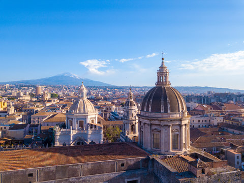 Aerial view of the Cathedral of Sant'Agata in the middle of Catania with Etna volcano on the background