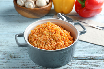 Dish with tasty lentil porridge on table