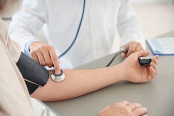 Doctor measuring patient's blood pressure in hospital