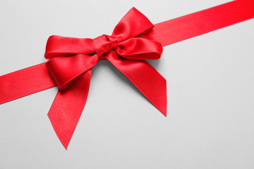 Beautiful red ribbon with bow on light background