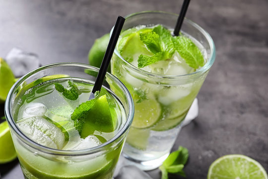 Refreshing beverage with mint and lime on table, closeup