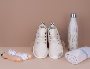 Shot of golden sneakers on beige background.