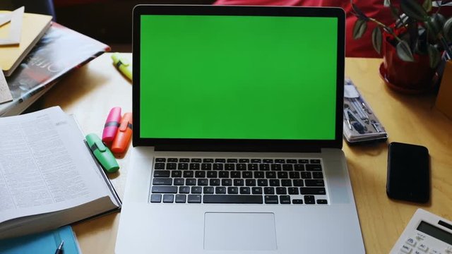 closeup shot of opened laptop computer with blank green screen mock up text content keyboard touchpad calculator study workplace chroma-key internet technology network business conversation website