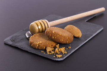 Honey and Cookies on a cardboard shale on a Black Background