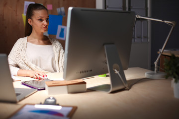 Young woman working in office, sitting at desk. Young woman.