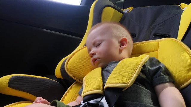 beautiful baby boy sleeping in car seat.