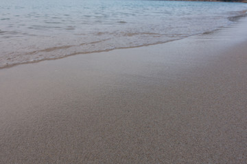 Beautiful background transparent surface wave, sand on clean seaside beach. Royalty high-quality free stock video footage of clean surface seawater, waves on the beach with sand and sunshine in summer