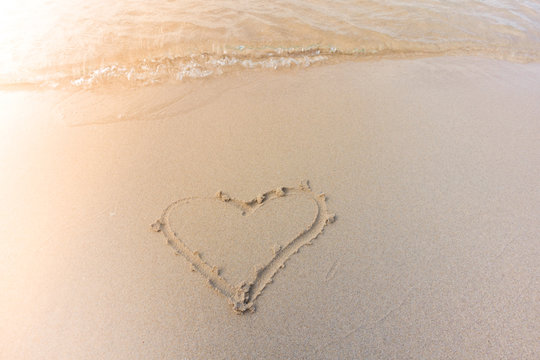 Beautiful background beach with heart in summer. Royalty high-quality free stock image of shape heart draw on the sand and beach