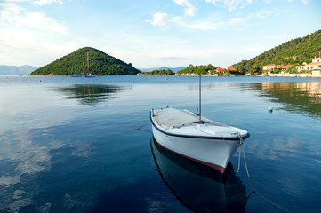Fototapeta na wymiar Small fishing boat tied into harbour on a beautiful sea