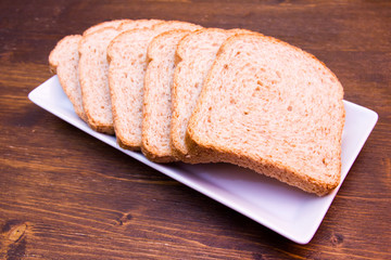 Slices of wholemeal bread on a wooden table viewed from close up