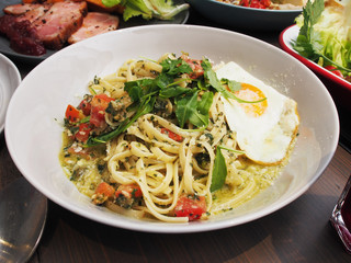 Arugula, parmesan & pesto pasta on wooden table