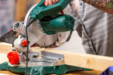 Man sawing wood with a circular saw on a workbench
